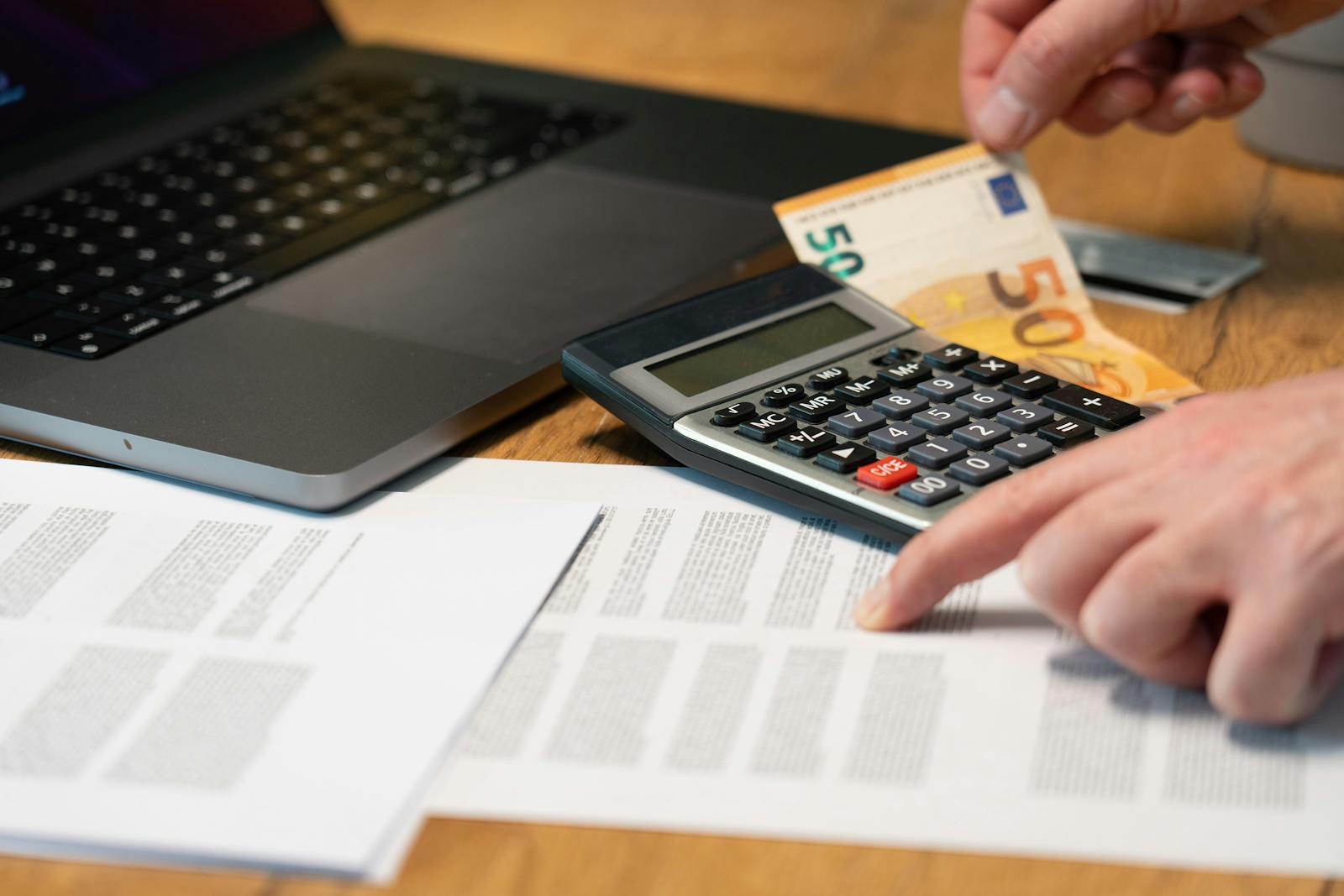 Comptabilité d'une TPE : ordinateur portable, calculatrice et documents financiers sur un bureau